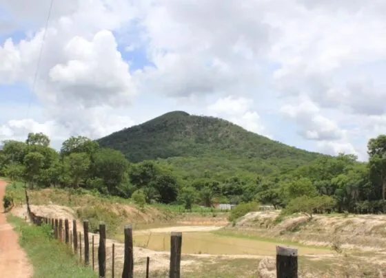 Imagem mostra estrada de terra para Morro de Santo Antônio e morro ao fundo.