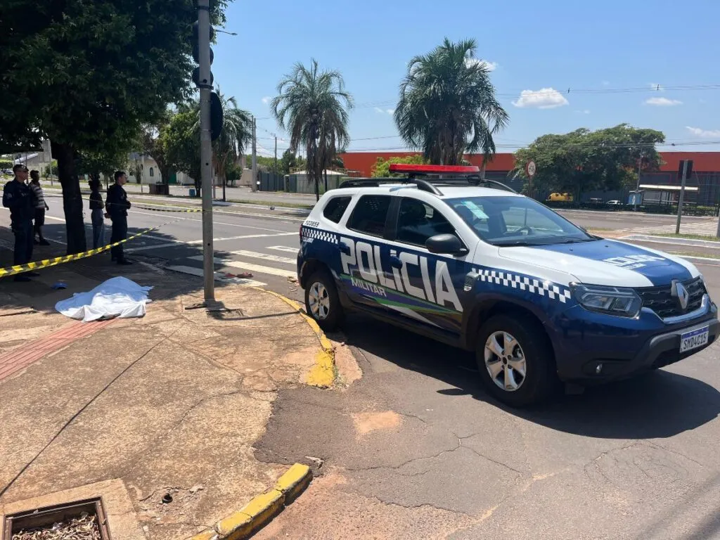 Polícia Militar no local do crime; corpo de homem em situação de rua ficou caído na calçada (Foto: Mateus Nunes)